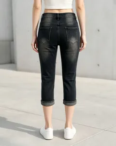 Dettaglio posteriore di jeans capri skinny da donna slavati con risvolto e tasche.