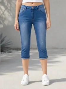 Primo piano dettagliato di pantaloni capri in denim elasticizzato blu indossati all'aperto.