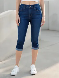Vista dettagliata di jeans capri elasticizzati blu scuro con risvolti alla moda.