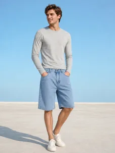 Vue détaillée du short en jean bleu clair décontracté pour homme associé à un haut gris.