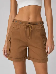 Primo piano dei dettagli di pantaloncini cargo marroni con coulisse e occhielli metallici.
