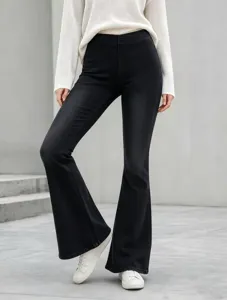 High waist black flare denim jeans detail, stretchy fitted slim pants worn with knitwear.