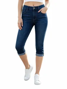 Dettaglio in primo piano di jeans capri da donna blu scuro, con risvolti e vestibilità slim.