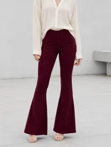 Close-up detail of high-waisted stretchy burgundy flare trousers worn with a white blouse.