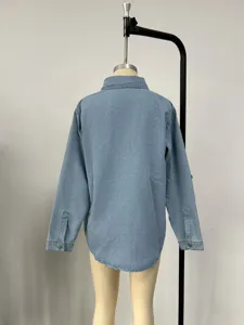 Back view detail of light blue denim shirt jacket showing back seam and long sleeves design.