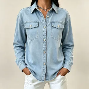 Light blue denim jacket detail showing front lapel, metal buttons and dual chest pockets.