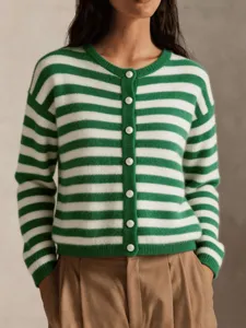 Vue détaillée d'un élégant gilet en tricot rayé vert et blanc avec de beaux boutons.