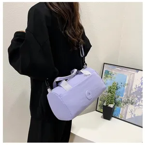Sac bandoulière cylindrique violet léger avec poignées confortables et sangle réglable au quotidien.