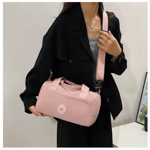 Sac bandoulière rose en nylon avec large sangle, sac oreiller minimaliste pour le quotidien.