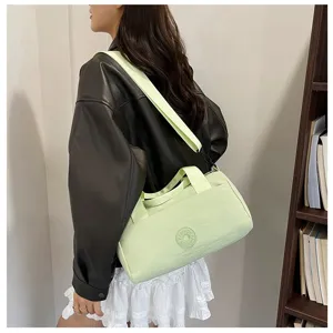 Détail de sac porté épaule cylindrique vert clair, sac besace coussin décontracté.