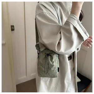 Vista dettagliata di una borsa a tracolla verde chiaro con coulisse, perfetta per tutti i giorni.