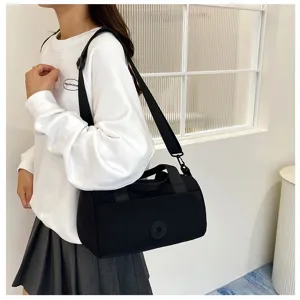 Sac à bandoulière cylindrique en nylon noir, sac fourre-tout léger et spacieux pour les déplacements.