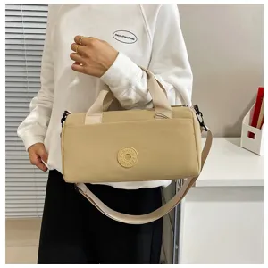 Sac à bandoulière cylindrique décontracté en toile unie avec poignée pour le quotidien.