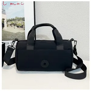 Sac bandoulière décontracté en toile noire avec poignées pour les trajets et voyages.