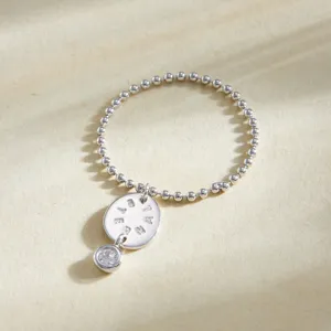 Gros plan détaillé de la bague en argent sterling avec pendentif gravé et zircon.
