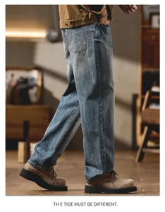 Detailed side view showing vintage washed denim jeans with loose curved cut styling.