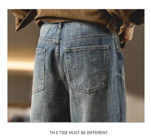 Detail view of American vintage washed loose curved denim jeans for men, casual wear.