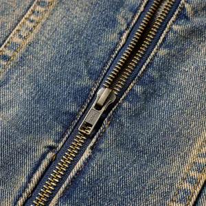 Gros plan détaillé d'une veste en jean gris fumé vintage avec une fermeture éclair métallique.
