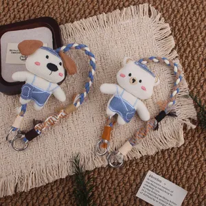 Detailaufnahme von süßen Cartoon Bär und Hund Plüsch Schlüsselhängern mit Retro Gurten.