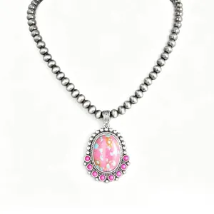 Bohemian vintage ethnic turquoise necklace, silver bead chain with pink pendant detail.