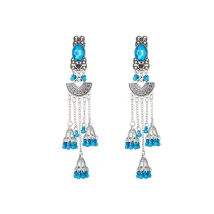 Detalle de pendientes largos étnicos de plata vintage con cuentas azules y colgantes.