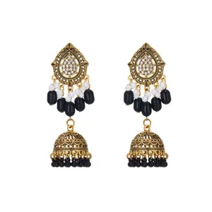 Close-up detail of antique gold ethnic jhumka earrings featuring rhinestones and black bead tassels.