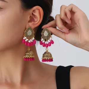 Ethnic vintage gold drop earrings with white pearls, crystal and tassels for women detail view.
