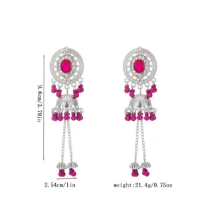 Exquisite hollow disc drop earrings detail view featuring vibrant magenta beads and sparkling rhinestones.