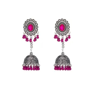 Primer plano de pendientes de campana de filigrana de plata boho con cuentas rosas vivas.