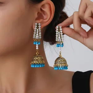 Boucles d'oreilles jhumka longues strass or ancien perles bleues femme détail gros plan
