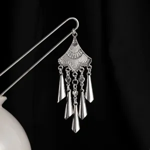 Detalle de horquilla étnica retro china, accesorio Hanfu con borlas múltiples.