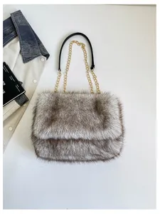 Detalle de bolso bandolera de felpa suave, piel sintética y cadena metálica elegante.