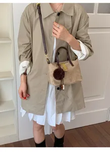 Chic suede crossbody bag for women, stylish shoulder bucket bag with furry charm and chain.