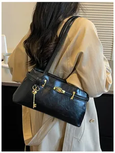 Sac à bandoulière uni minimaliste avec cadenas doré et détails métalliques élégants.