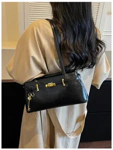 Sac à épaule noir minimaliste pour femme, sac à main tendance chic avec fermoir métallique.