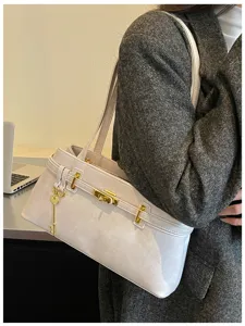 Sac à main élégant et minimaliste pour femme, design chic avec fermoir métallique doré.