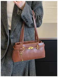 Vue détaillée de l'élégant sac à bandoulière marron doté d'un verrou doré chic.