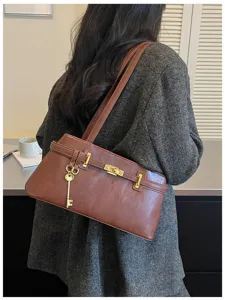 Vue détaillée du sac à bandoulière marron élégant avec cadenas doré, style automnal.