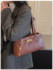 Détail de sac à bandoulière en cuir PU marron, sac à main élégant pour femme avec cadenas et clés.