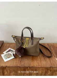 Chic brown suede crossbody bag with elegant chain and cute pom-pom charm for autumn daily wear.