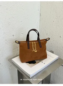 Brown suede top handle handbag detail, elegant gold chain hardware accent on sleek daily bag.
