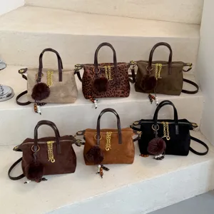 Stylish suede crossbody shoulder bags for women, featuring chic plush ball and chain charms.