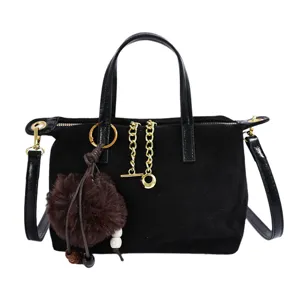 Black suede crossbody bag for women, stylish shoulder handbag with plush pom pom and chain.