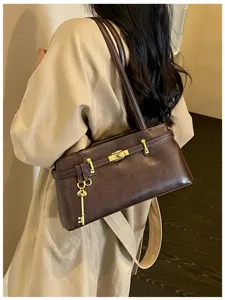 Vue de detail d'un sac a epaule elegant en cuir marron avec un cadenas pour les femmes.