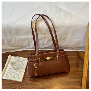 Sac à épaule en cuir marron avec serrure dorée et charmant pendentif clé élégant.