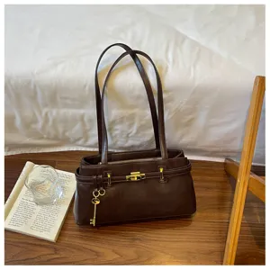 Élégant sac à épaule en cuir marron foncé pour femmes avec fermeture métallique.