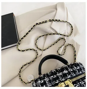 Stijlvolle zwart-witte tweed crossbody tas met gouden ketting en chic lederen handvat.
