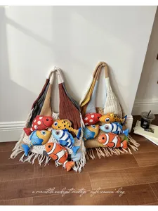 Gedetailleerd overzicht van gebreide color-block tote bag met schattige pluche vissen en franjes.