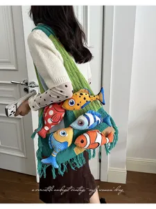 Detailweergave van de stijlvolle kleurblok gebreide tote tas met schattige pluche vissen.