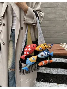 Gedetailleerd overzicht van stijlvolle color-block gebreide shopper met pluche vissen en franjes.